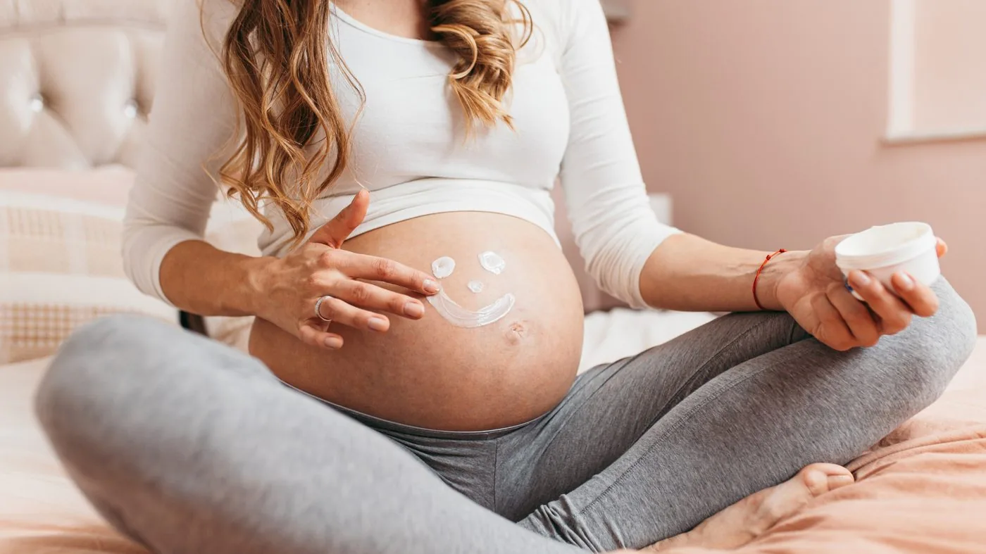Embarazada sonriendo con las manos en la barriga